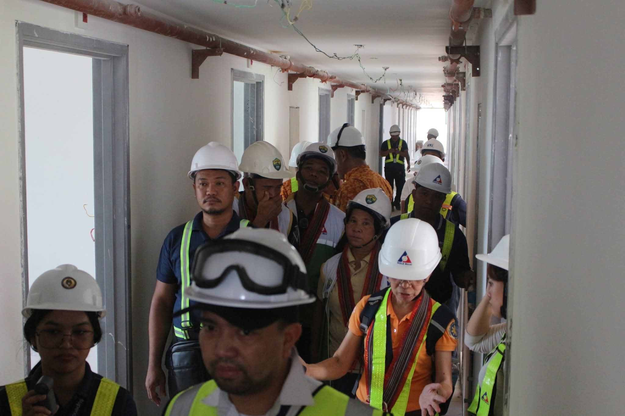 DOLE Bicol personnel and partner agencies conduct an on-site walkthrough to check workplace safety and labor standards compliance at the construction project. (NFrilles/PIA 5-Camarines Sur)