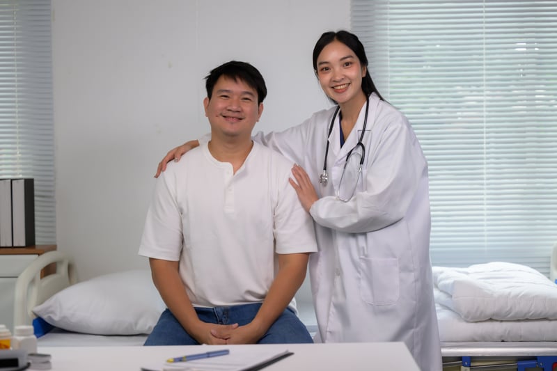 Female doctor supporting smiling male patient in clinicpaegagz