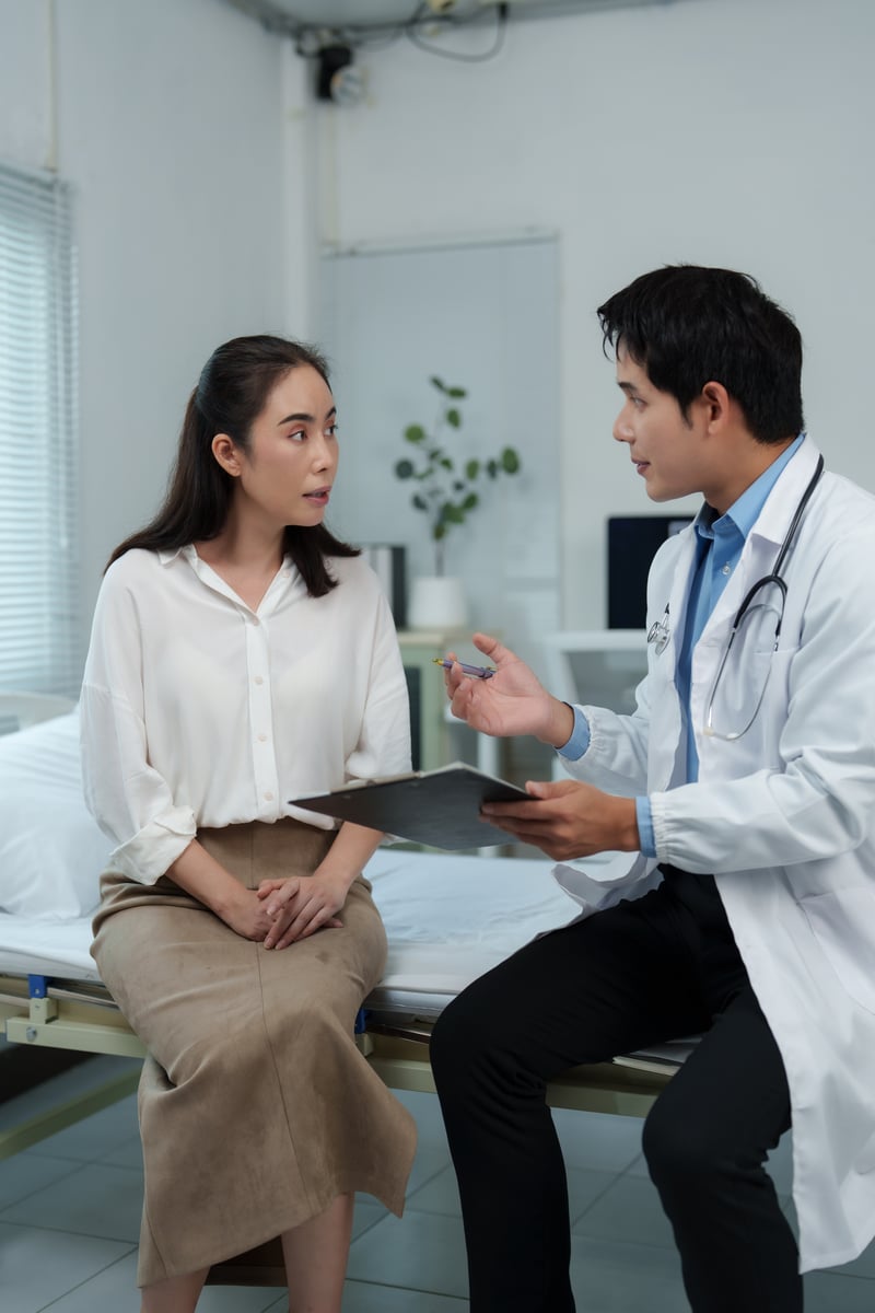 Doctor explaining diagnosis to young patient in hospital roomchartchaik1