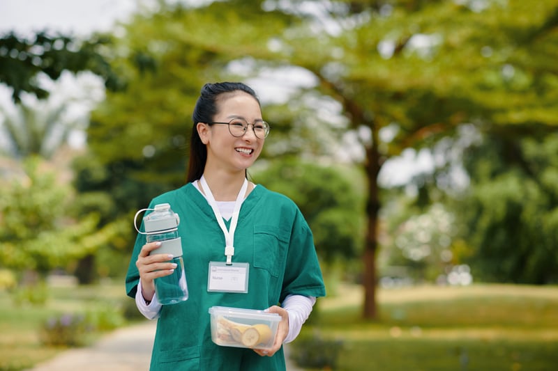 Smiling Woman Nurse Holding Water Bottle OutdoorsDragonImages