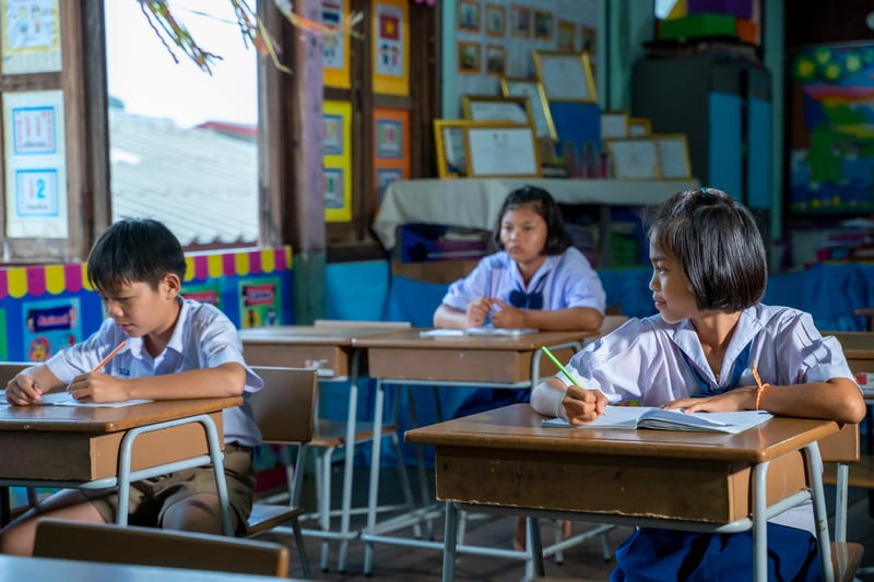 Elementary school kids sitting at desks in classroom,education,learning and people concept.visootu2