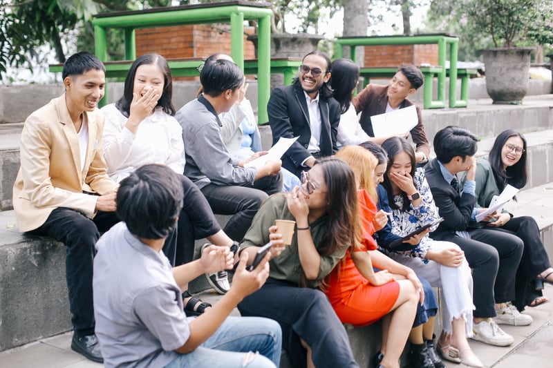 Smiling Group Sitting on Steps Outdoors during DaytimeGarakta-Studio