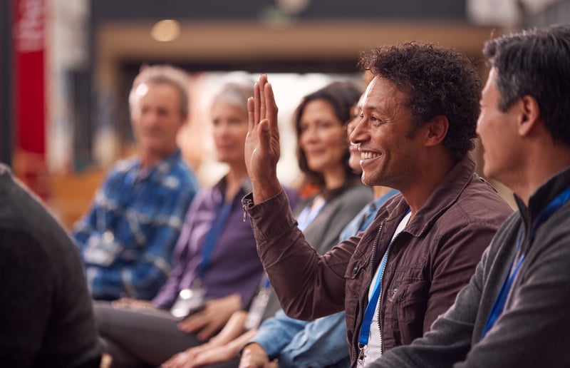 Man with Raised Hand at Corporate Presentationmonkeybusiness