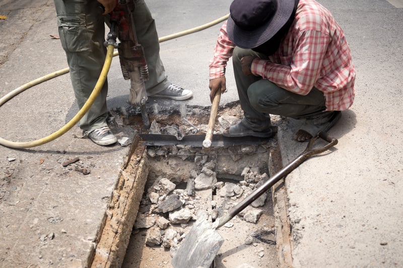 Worker Working On The Road Site Demolishing Asphalt With Pneumatic Plugger HammerOaklandImages