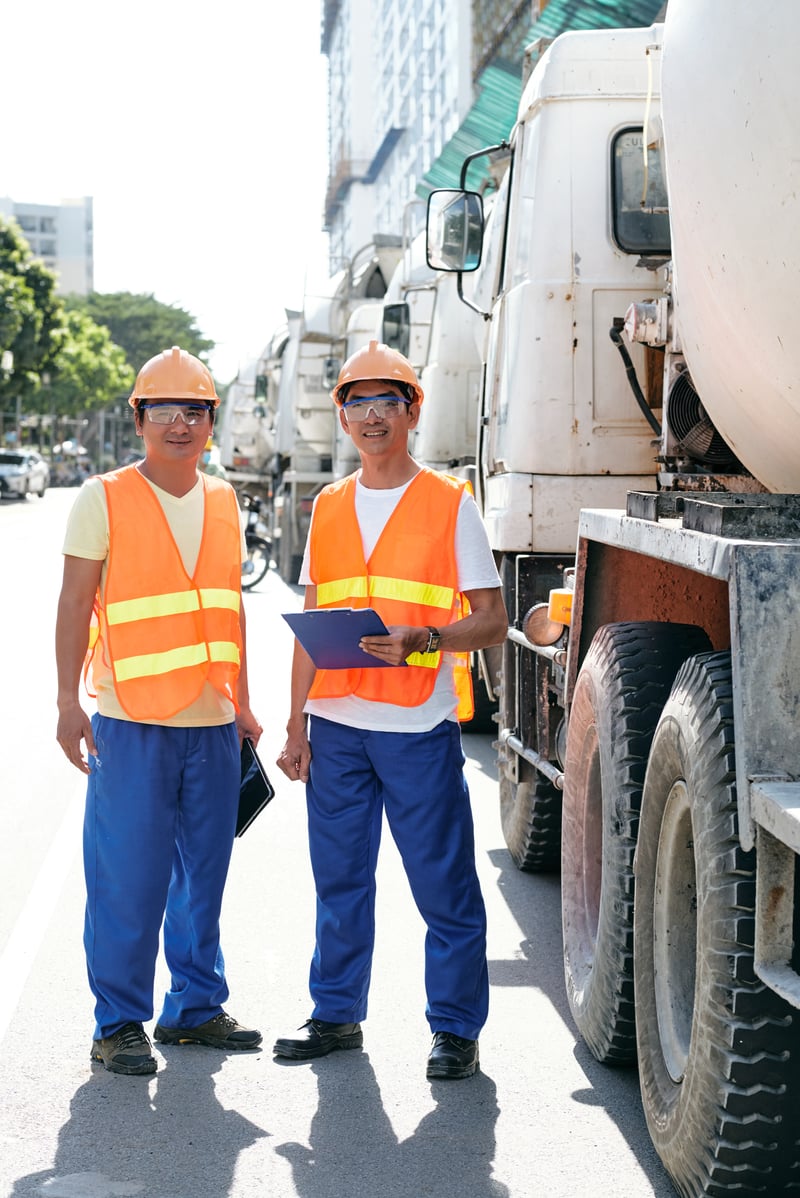 Construction Workers Standing near Concrete Mixer TrucksDragonImages