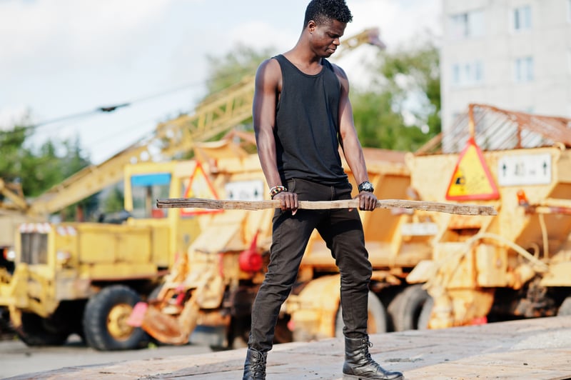 Young Man Poses in Front of Construction EquipmentASphotostudio