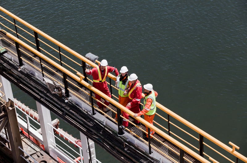Workers in Hardhats on a Metal Walkwayimagesourcecurated