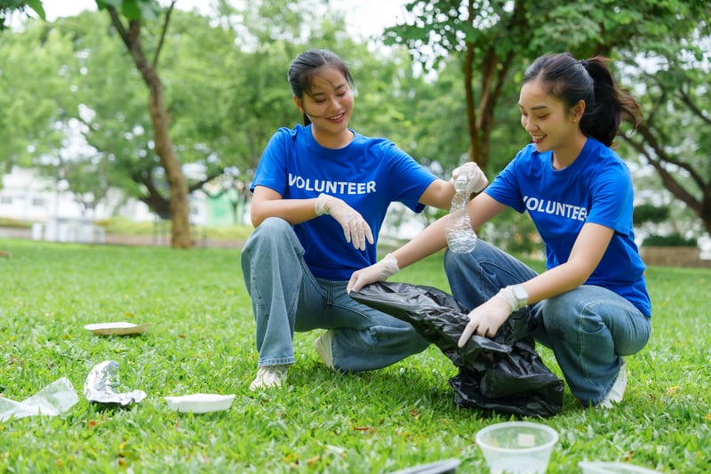 Volunteers collecting plastic bottles and trash in park cleanupchartchaik1