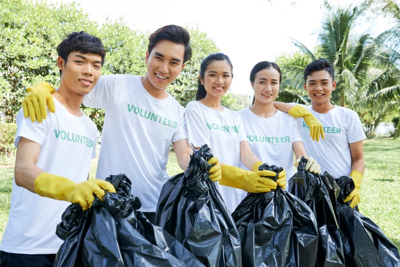 Happy Volunteers Cleaning Up Trash in ParkDragonImages