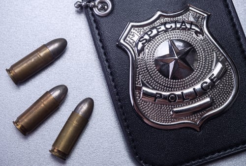 Polished Silver Special Police Badge Beside Three Brass Bulletsfelipecaparros