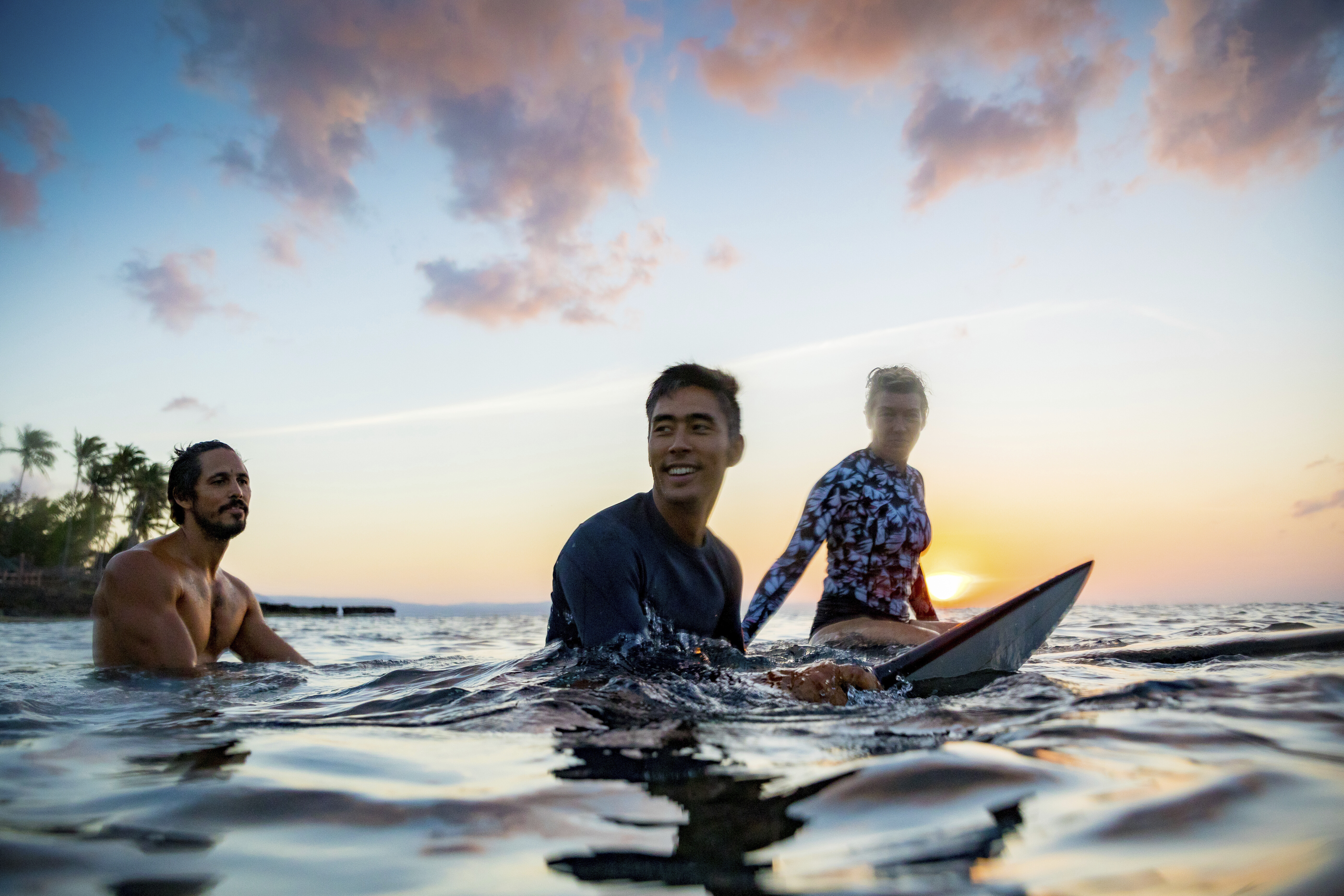 Surfers gliding in sea at sunset, Pagudpud, Ilocos Norte, Philippines