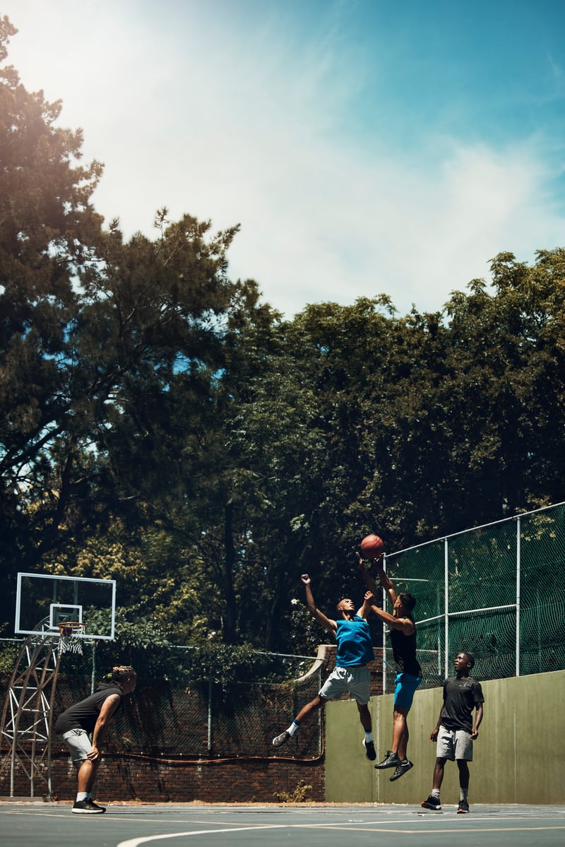 Athletic Men Playing Basketball Outside on Sunny DayYuriArcursPeopleimages