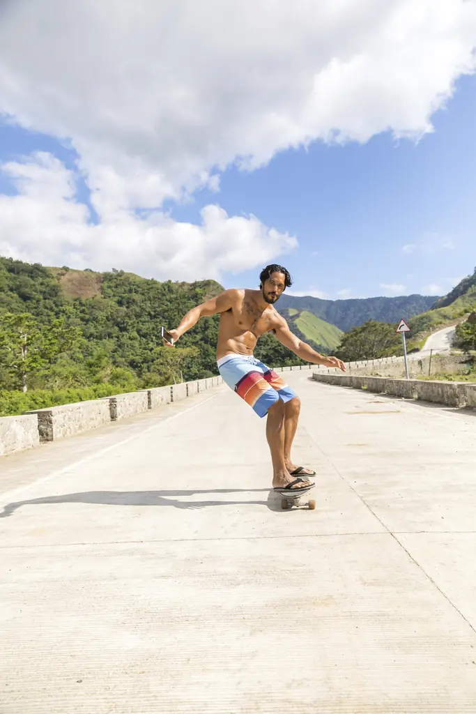 Man skateboarding on road, Pagudpud, Ilocos Norte, Philippines