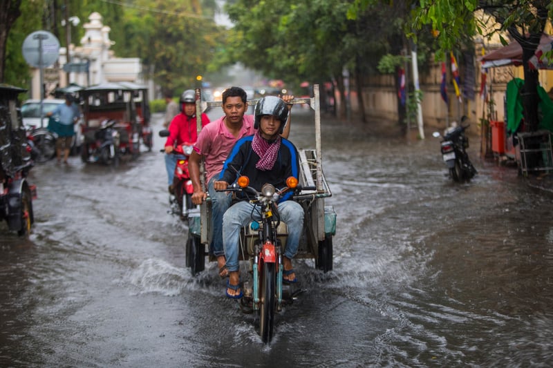 Motorcyclists navigating a flooded city street.Image-Source