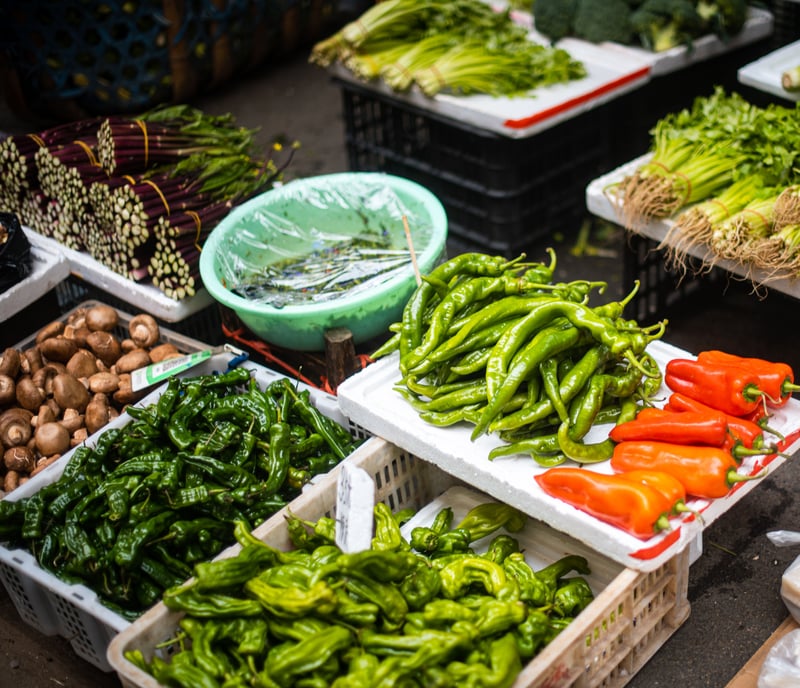 Abundant variety of fresh vegetables and fruits on sale at a vibrant outdoor market stallwirestock