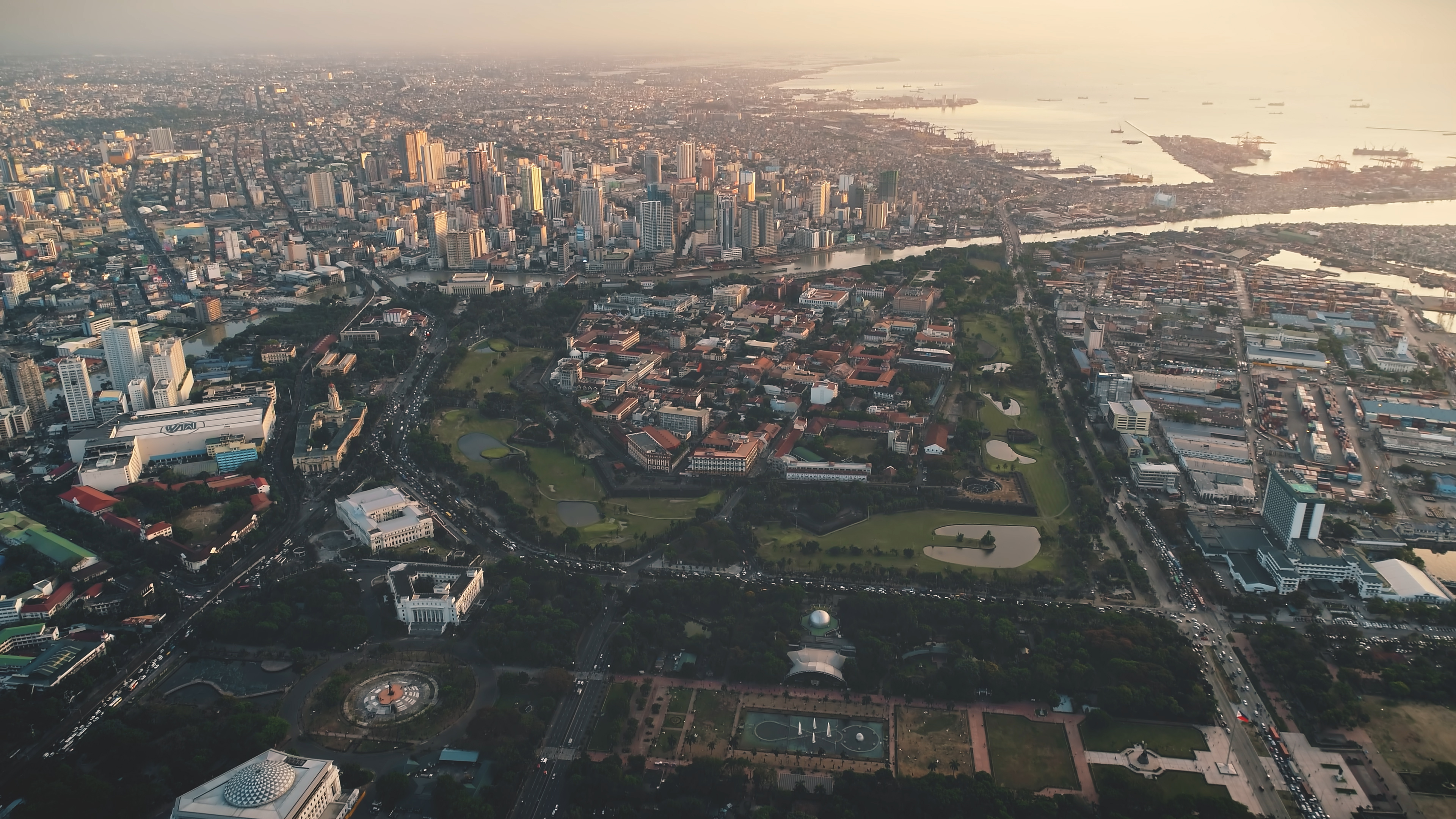 Modern buildings at cityscape of Manila city aerial. Harbor town at ocean bay, urban streets, roads