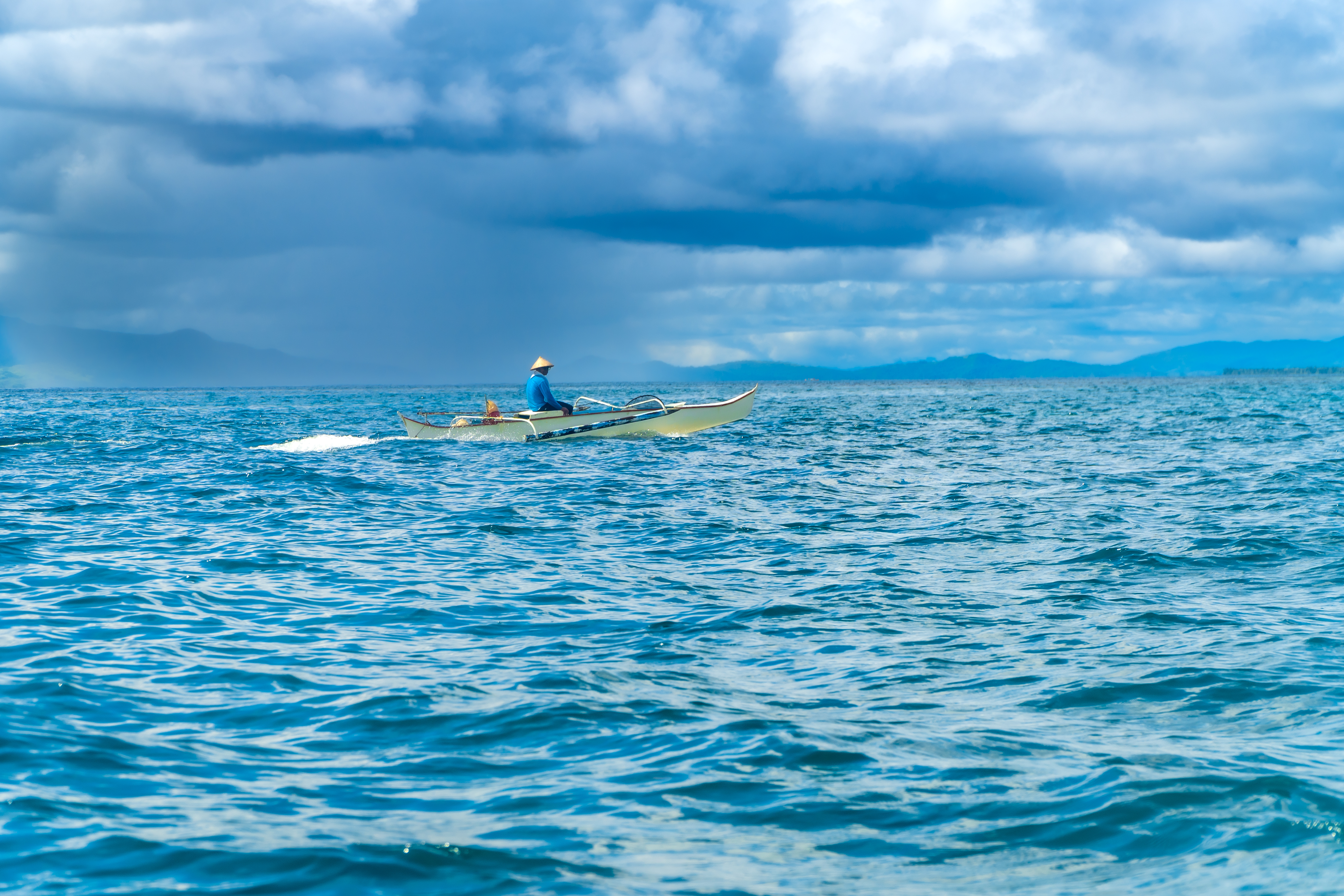 Filipino fisherman navigating the waters of siargao island, philippines