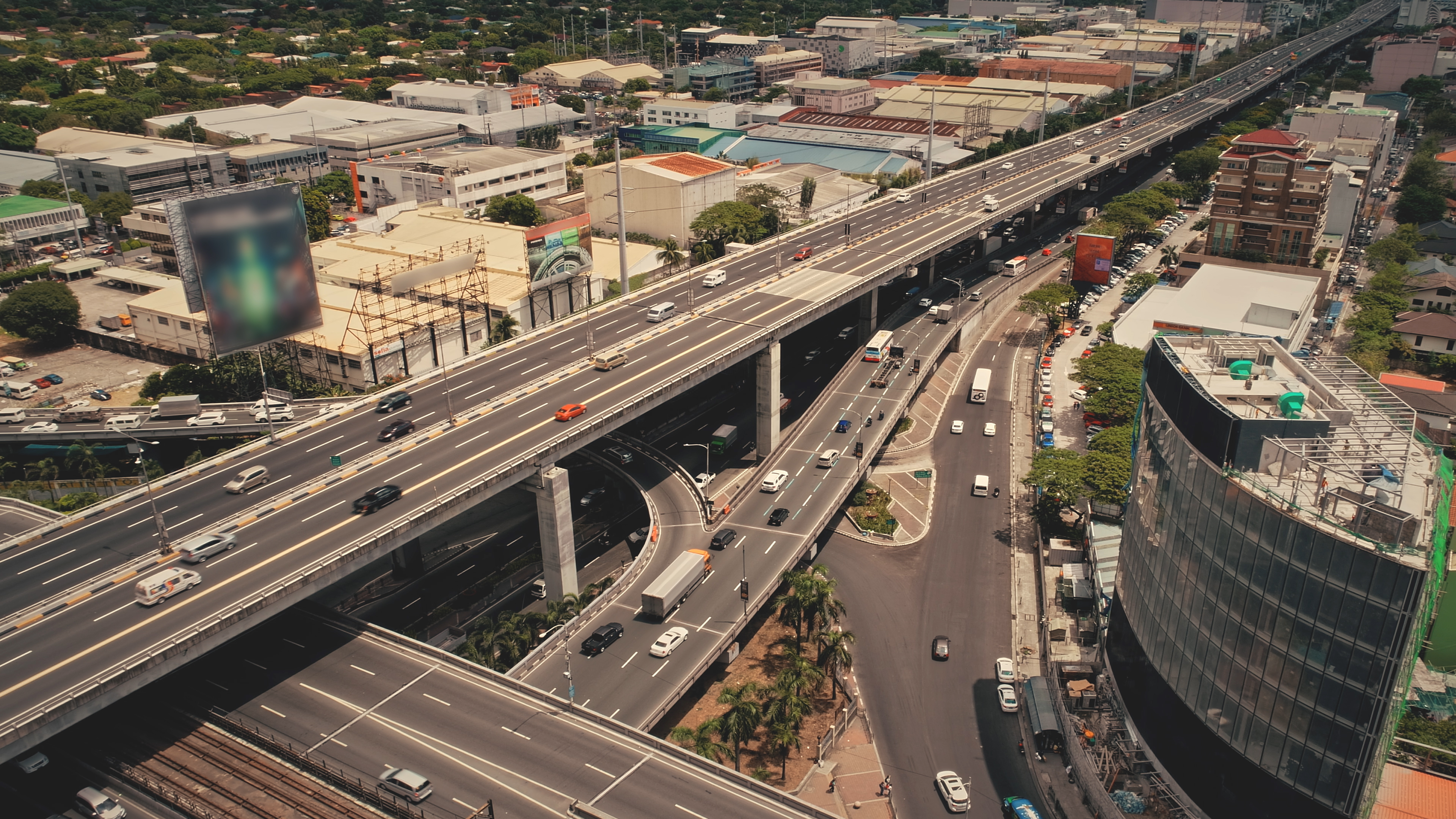 Modern skyscraper at traffic road with cars. Manila downtown aerial. Cityscape advertising billboard