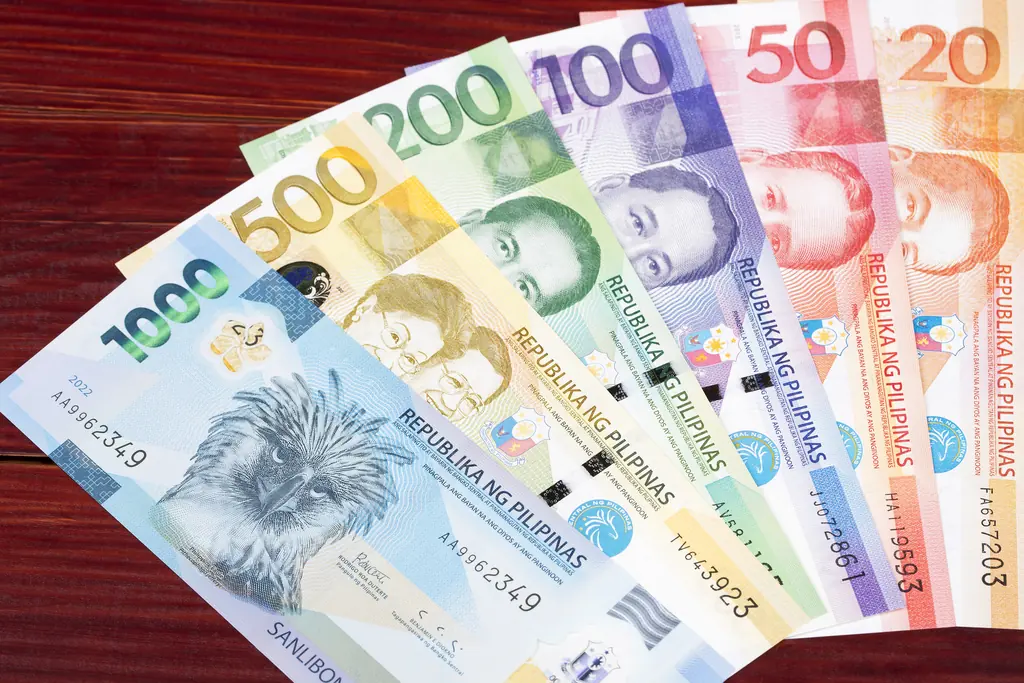 Assorted Philippine Peso Banknotes on Wooden Surface
