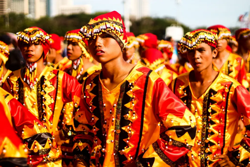 Colorful Filipino street festival featuring vibrant traditional costumes in a lively outdoor setting.