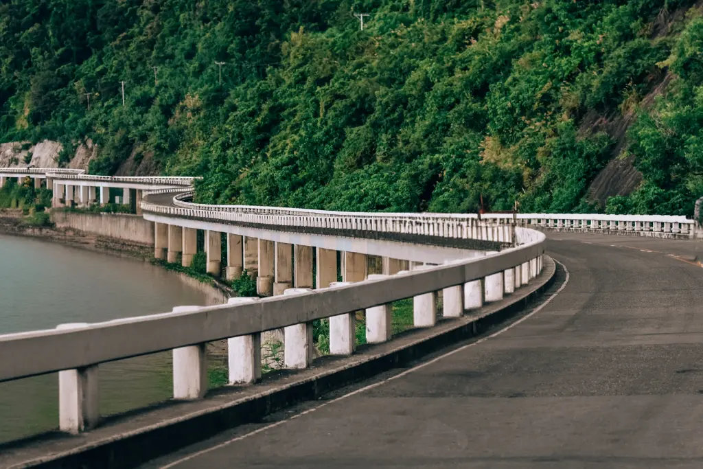 Curving coastal highway along lush greenery in the Ilocos Region, offering a picturesque view of nature and engineering.
