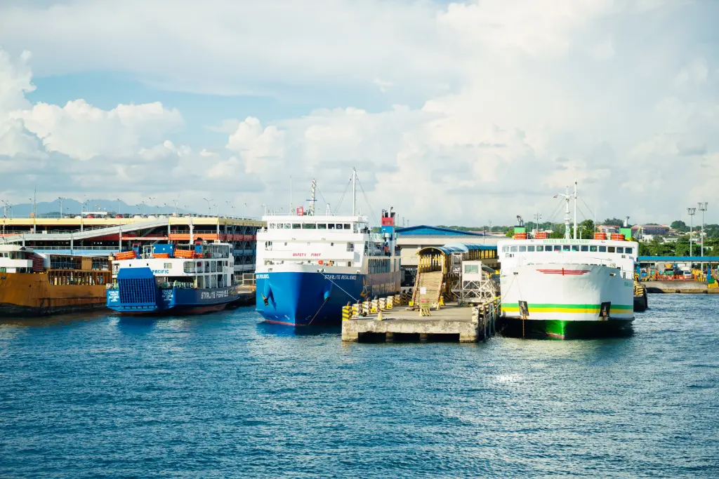 Vibrant ferries docked at a busy port under clear skies, showcasing maritime activity.
