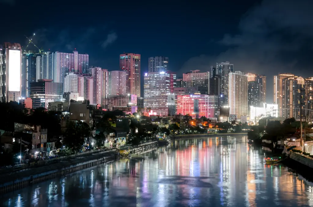 Beautiful night view of Makati City's illuminated skyline reflecting on the river.