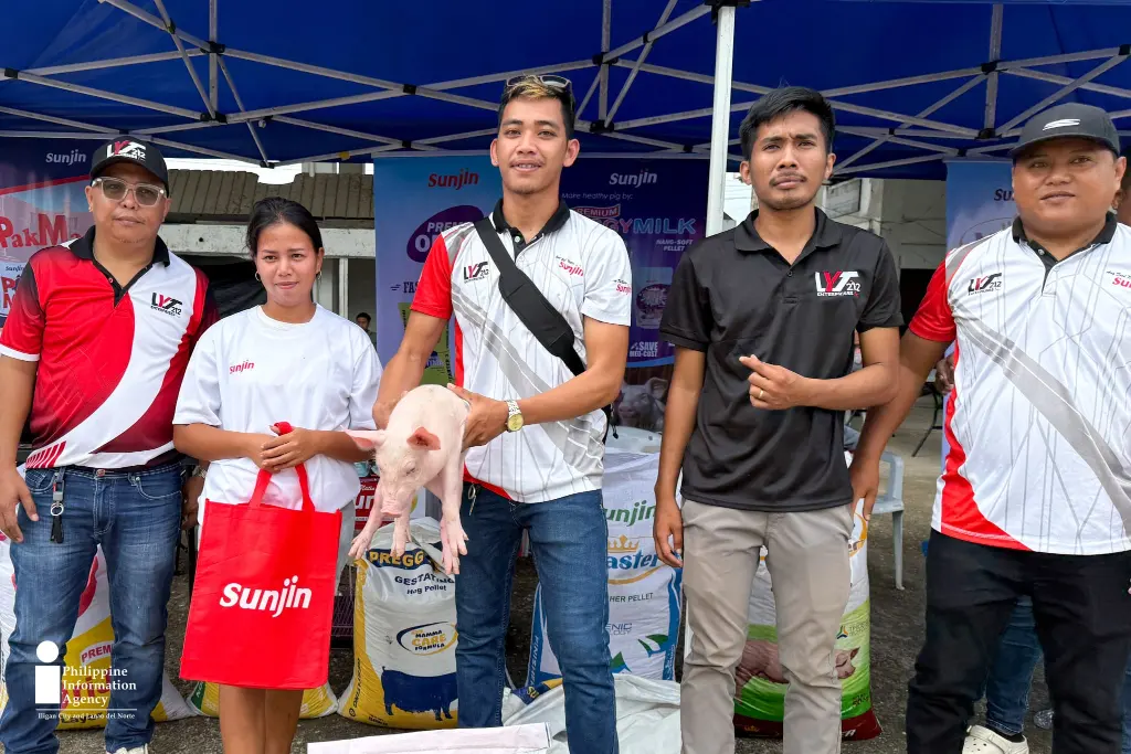 Kyle Mabugnon poses with the pig she won in the Pig-catching Contest, along with animal feeds provided during the Livestock Day celebration held as part of the 67th Araw ng Lanao del Norte in Tubod. The prizes support backyard hog raising and help beneficiaries reduce production costs. (Photo: LELA/PIA-10/Lanao del Norte) Bringing home livelihood support-