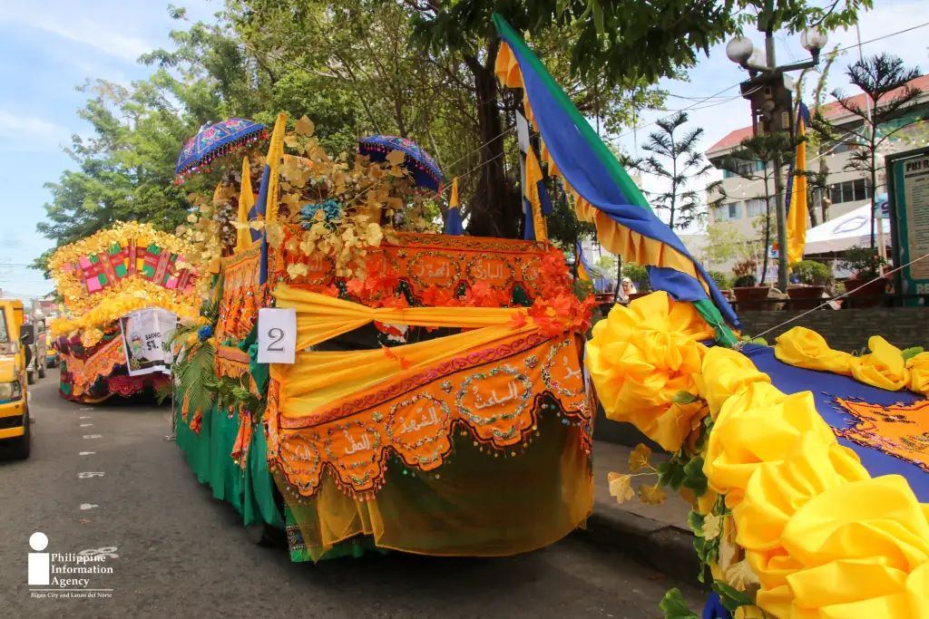 Barangay Santa Elena’s boat-inspired float, decorated with colorful textiles, traditional umbrellas, and tudong (traditional food covers), joins the Maranao Float Parade in Iligan City as part of the 4th Pakaradiyaan Festival. (Photo: SBZ/…