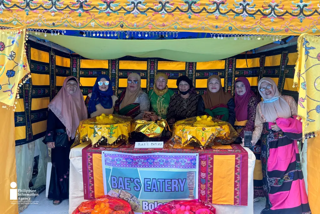 Participants gather at their intricately decorated booth during the Meranaw Food Festival, showcasing time-honored recipes and cultural pride as part of the 4th Pakaradiyaan Festival in Iligan City. (SBZ/PIA-10/Lanao del Norte) Celebrating Maranao flavors-