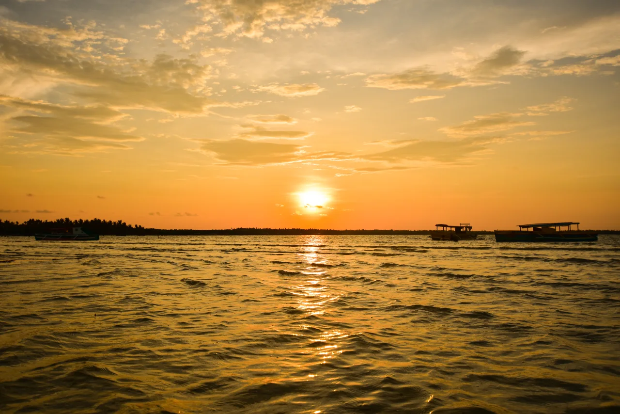 Sonnenuntergang am Tondol Beach mit Booten auf dem Wasser