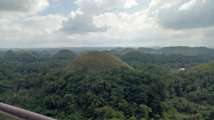 Grüne kegelförmige Kalksteinhügel auf Bohol unter bewölktem Himmel