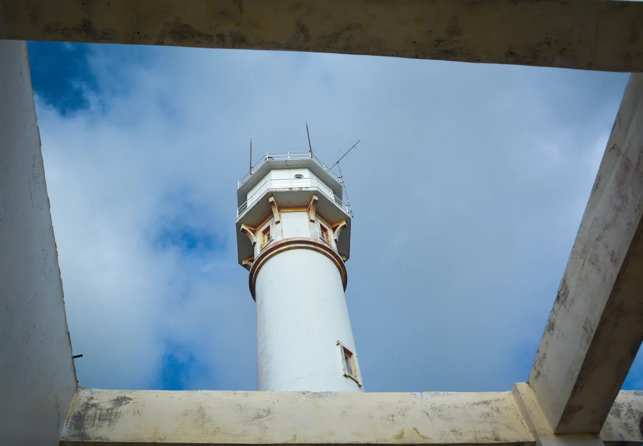Blick von unten auf den Cape Bolinao Lighthouse zwischen Betonbalken