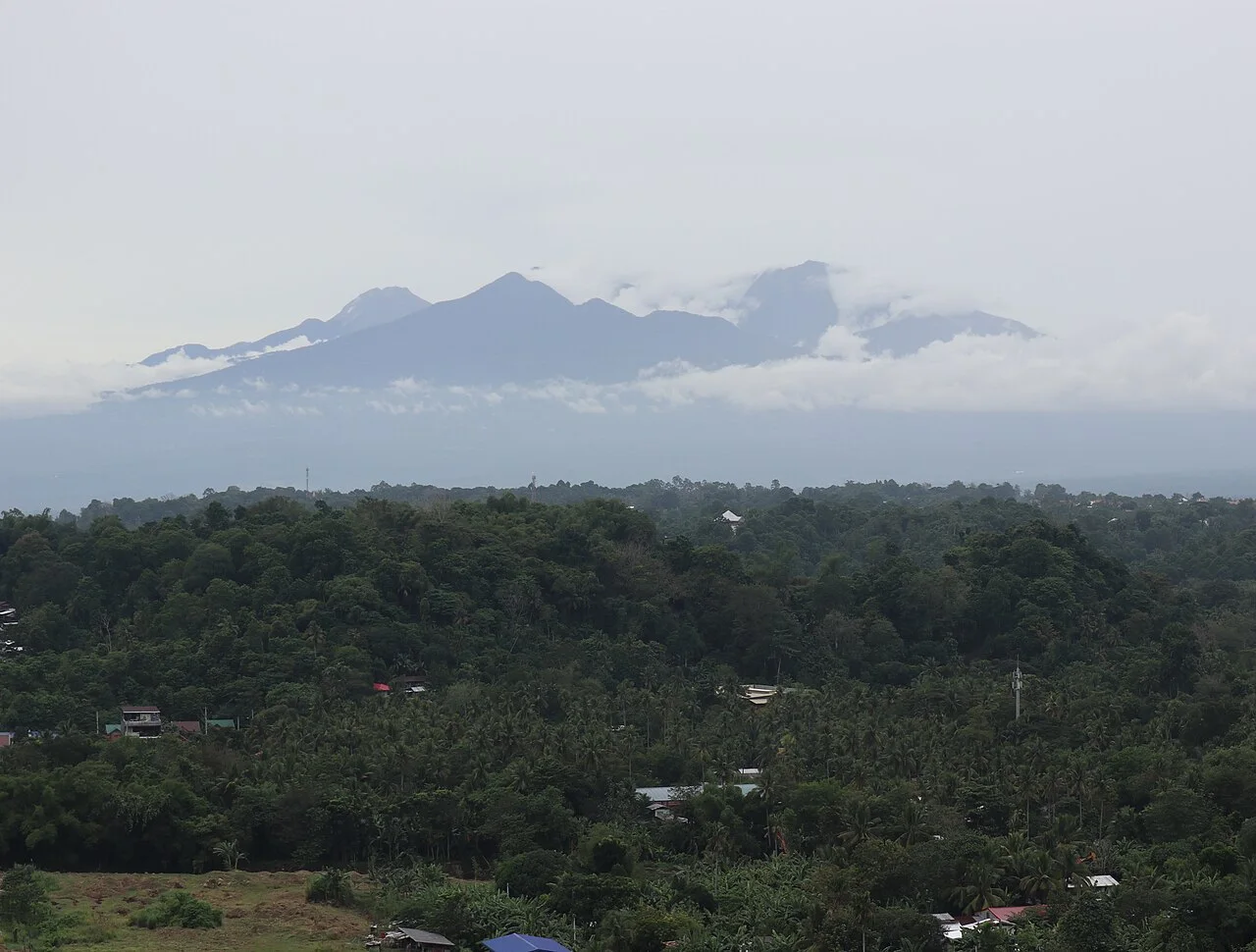 Bewaldete Hänge und Gipfel des Mount Apo unter Wolken