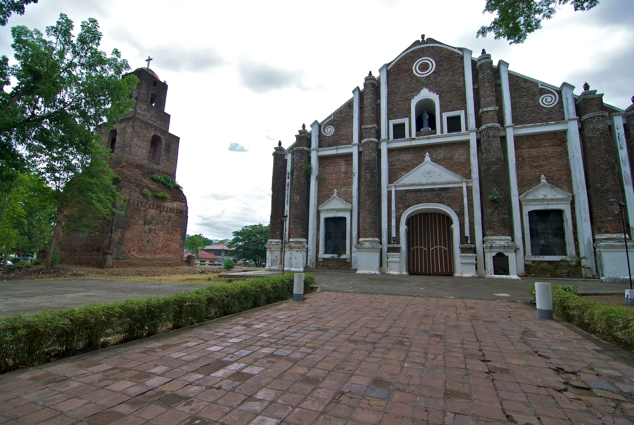 Backsteinfassade der Santa-Monica-Kirche in Sarrat mit freistehendem Glockenturm