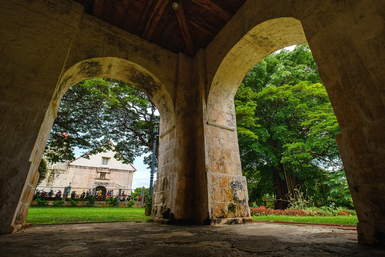 Blick durch steinerne Bögen auf die Kirche von Lazi auf Siquijor