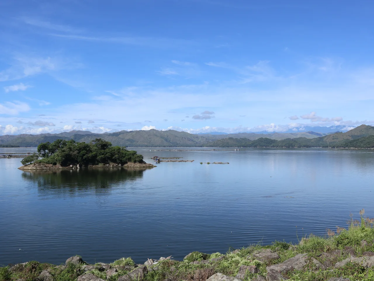 Magat-Stausee mit bewachsener kleiner Insel und Bergen im Hintergrund