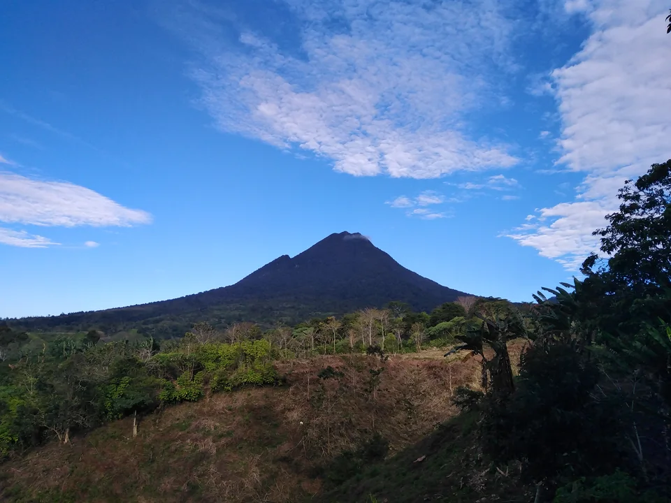 Der bewaldete Kegel des Mount Matutum unter einem blauen Himmel