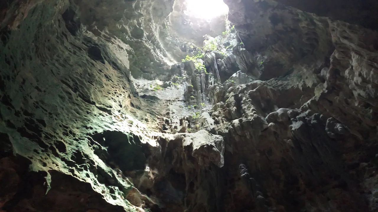 Tageslicht fällt durch eine natürliche Deckenöffnung auf die Felswände der Callao Cave