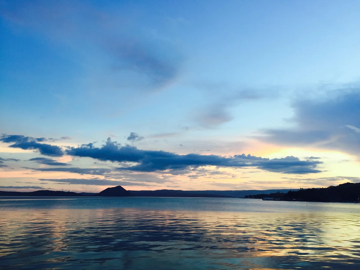 Taal-See im Abendlicht mit dunklen Ufern am Horizont