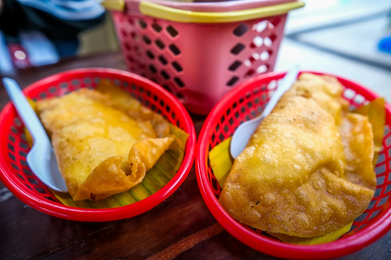 Zwei frittierte Empanadas in roten Körben mit Besteck
