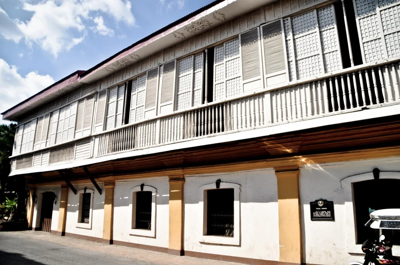 Seitenansicht der Syquia Mansion mit langem hölzernem Obergeschoss und Fensterreihen